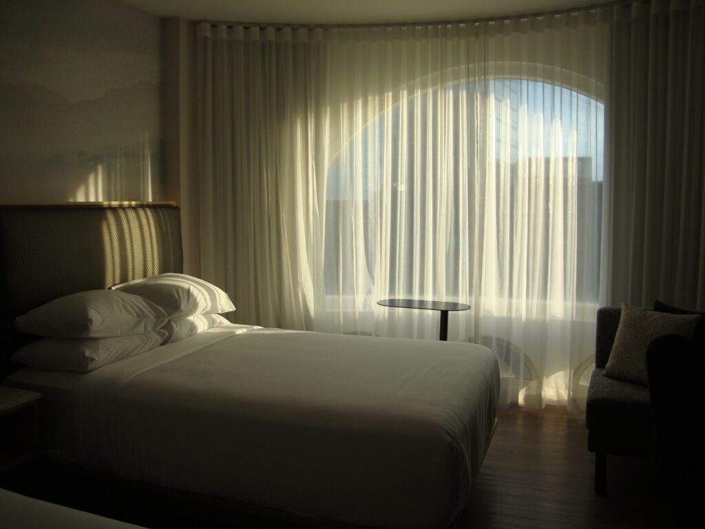 a bed sitting in a bedroom next to a window