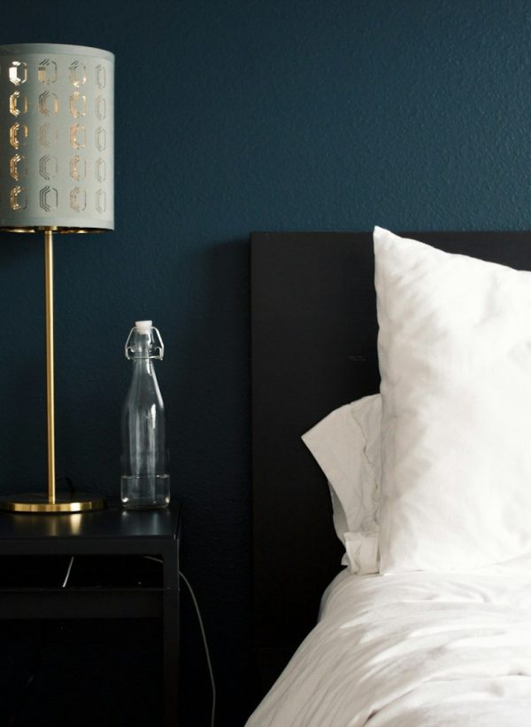 gray table lamp beside white bed pillow